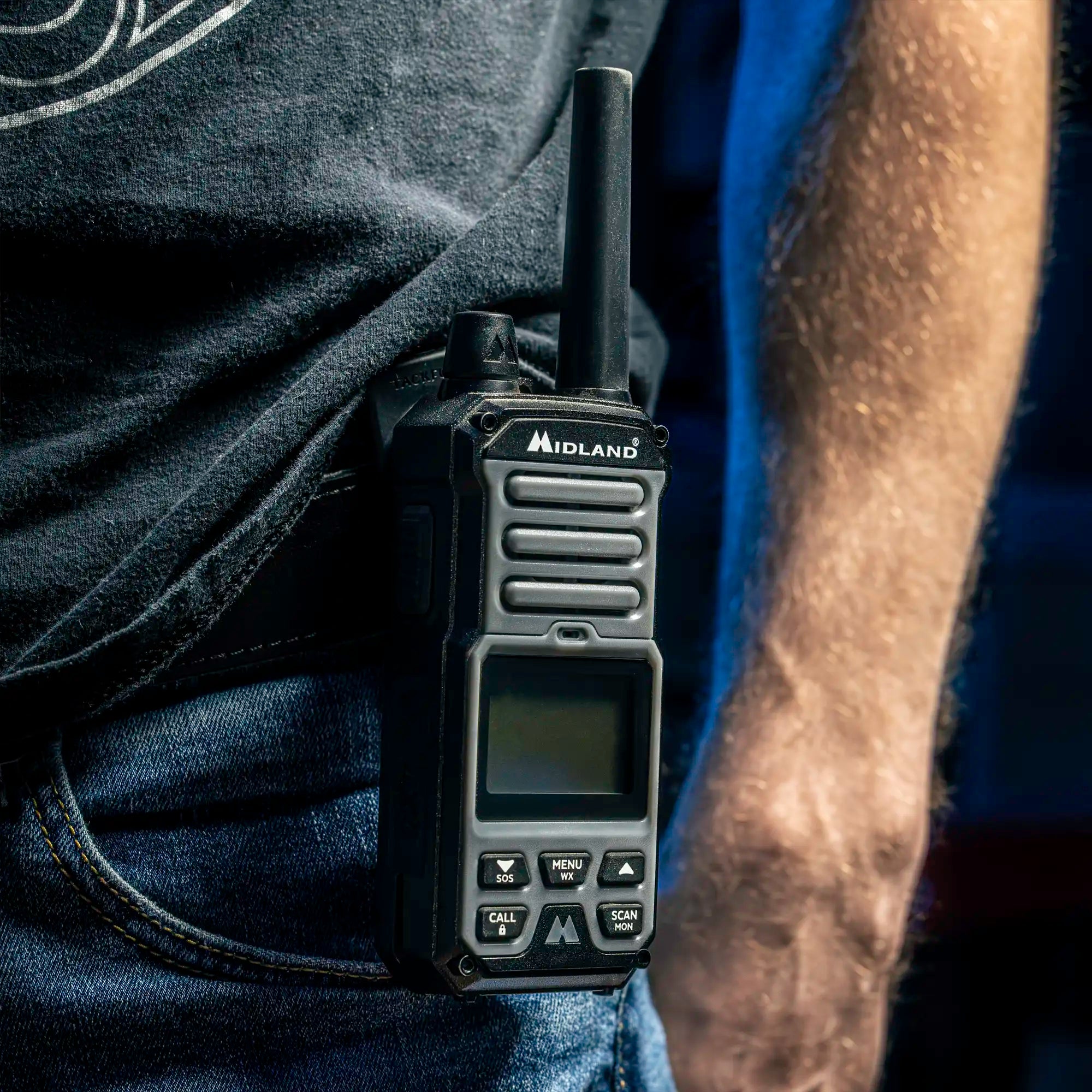 Man wearing a magnetic belt clip receiver with a Midland handheld radio attached