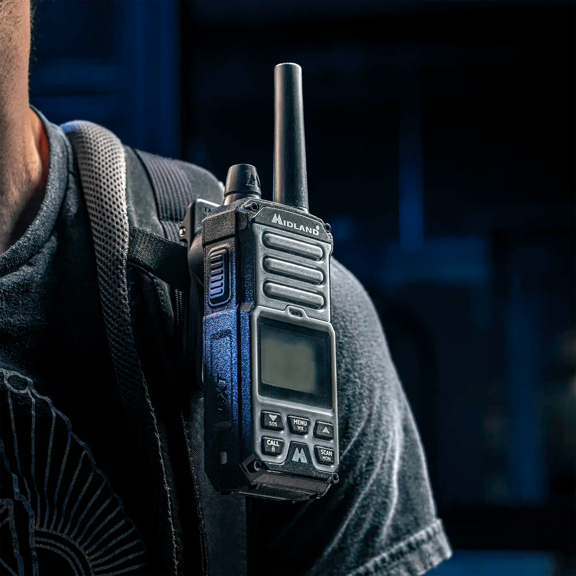 Black handheld radio from Midland magnetically attached to backstrap using handheld radio belt clip with magnetic receiver