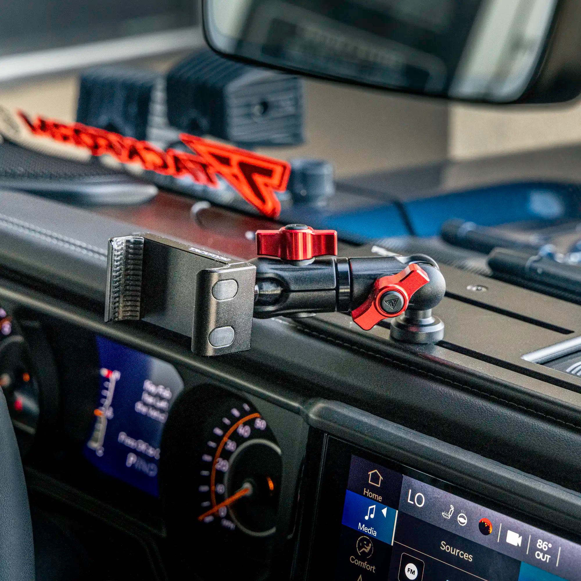 all-metal phone mount with red accents on a full-width dash bracket installed in a jeep gladiator