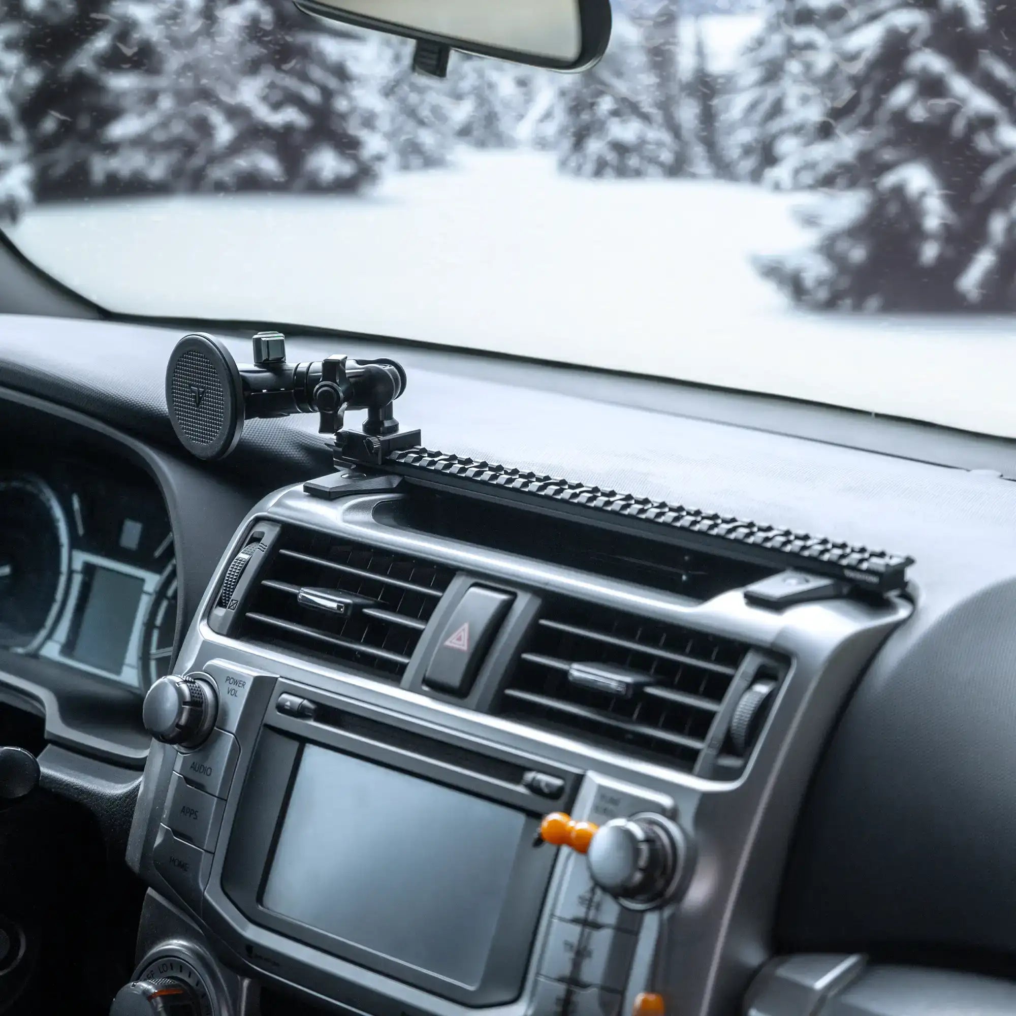 Lifestyle photo of 5th Gen 4Runner Phone Mount compatible with MagSafe for iPhone installed on the 4Runner dashboard with Tackform Assault Track Picatinny Dash Bracket