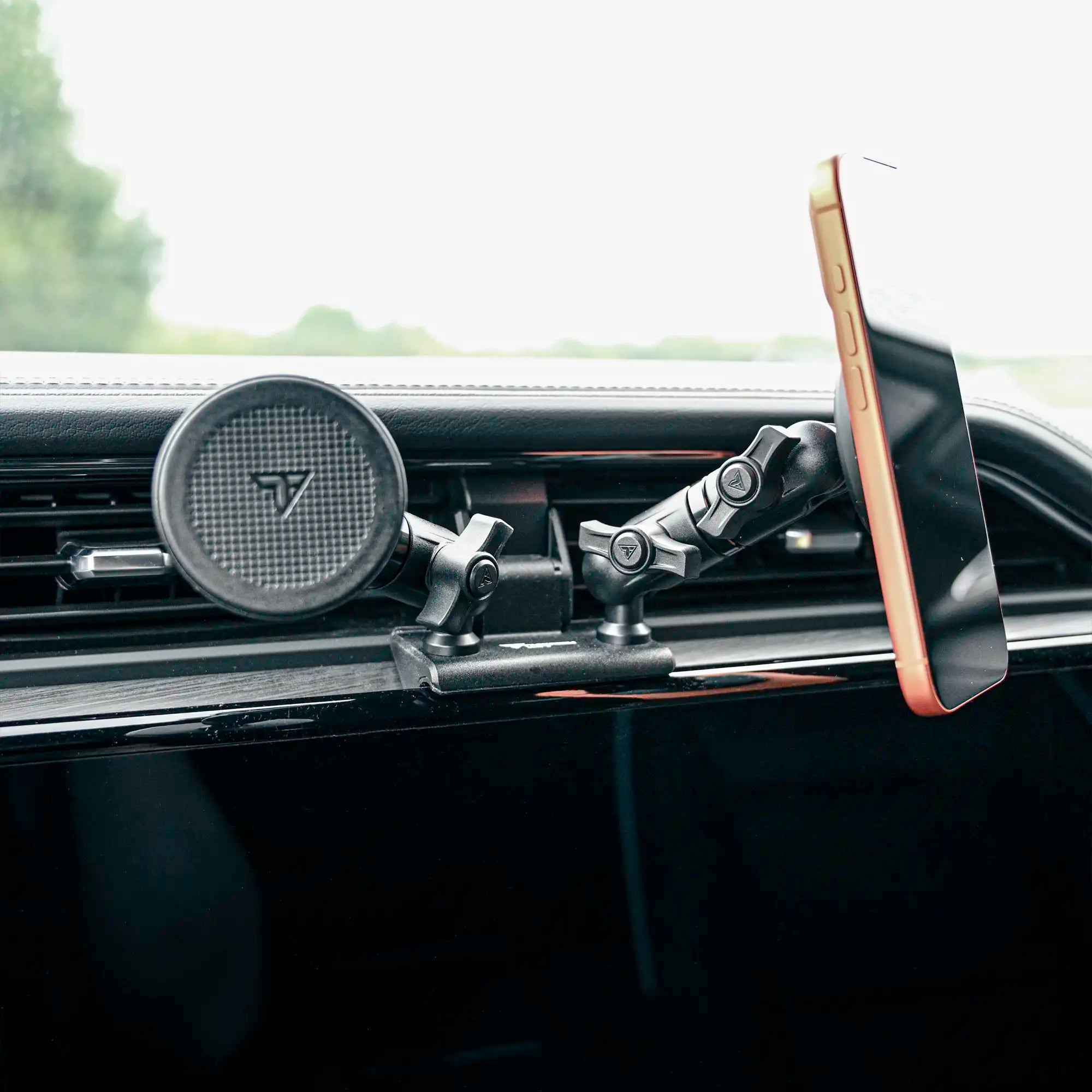 Black Tackform MagSafe compatible magnetic phone mounts attached to all-metal dash clip installed in a GMC Sierra